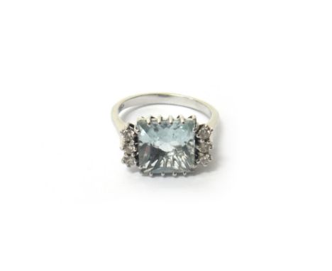 A white gold, aquamarine and diamond ring, claw set with the square cut aquamarine at the centre, between circular cut diamon