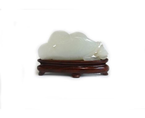 A Chinese pale celadon jade carving of a carp with lotus, 20th century, 7.5cm.length, wood stand.  Purchased in Hong Kong in 