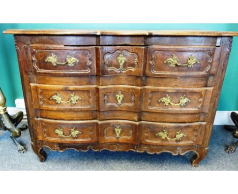 An 18th century French oak commode, with three shaped drawers flanked by rounded corners, on squat cabriole supports, 130cm w