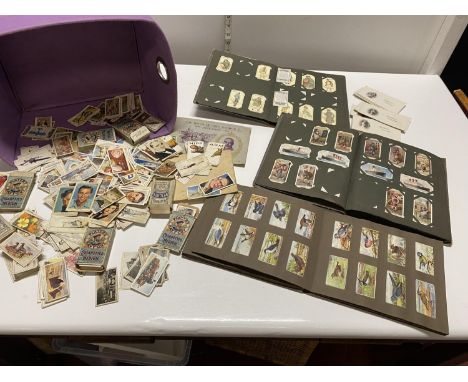A selection of vintage and antique cigarette card albums with loose cards