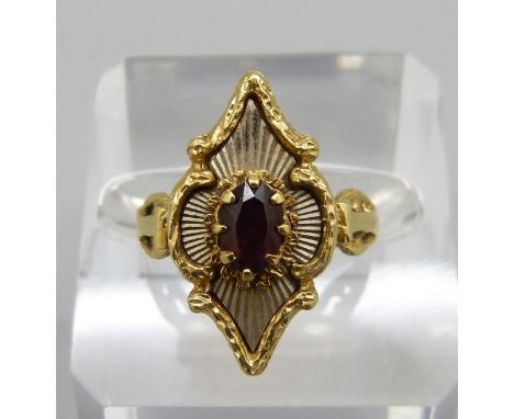 A yellow metal and garnet ring marked 750, 5.4g, O 