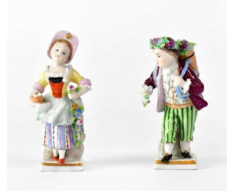 SITZENDORF; a pair of porcelain figures, the woman carrying flowers and a nest of eggs, the gentleman carrying a basket of gr