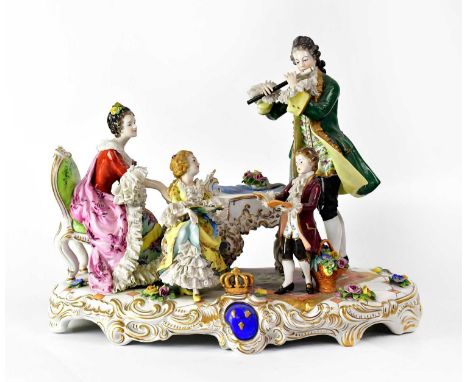 A 20th century German porcelain figure group of a family playing musical instruments and singing around a piano, floral encru
