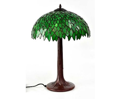 A Tiffany-style table lamp with green shade, on painted metal base in the form of a tree trunk, height 57cm.
