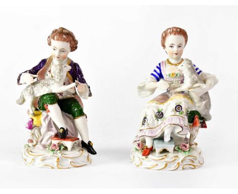 SITZENDORF; a pair of porcelain figures of a boy and girl, each with a lamb on their knee, each on Rococo-style base, printed