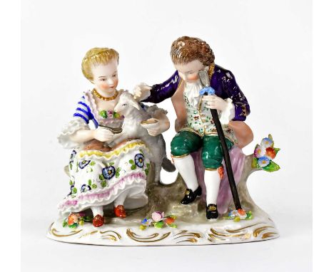 SITZENDORF; a porcelain figure group of a couple feeding a lamb, the woman with the lamb on her knee and the gentleman holdin
