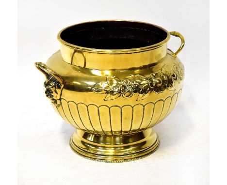 A 19th century large brass planter, with two mask handles, repoussé floral decoration and copper interior, on fluted base, he