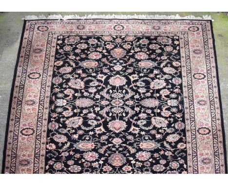 A Caucasian wool carpet of blue and cream ground, with floral and scrolling motifs within multi borders, 363 x 274cm. 