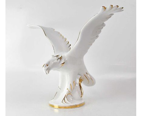 A large Continental white glazed and gilt-heightened ceramic figure of an eagle with outstretched wings, on oval base, unmark