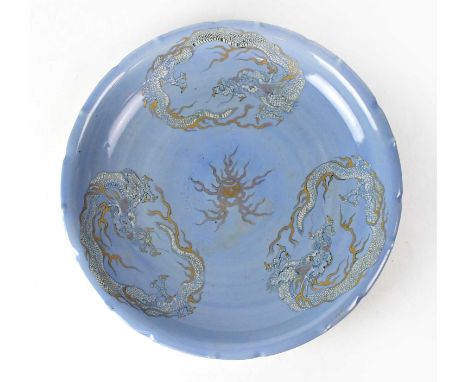 A Chinese porcelain charger of pale blue ground with scalloped edge, painted with three dragons with gilt highlighting and ce