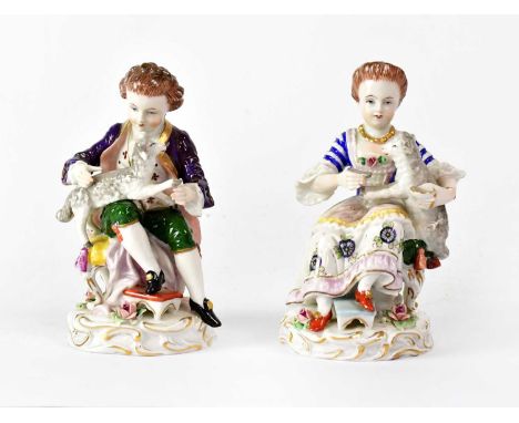 SITZENDORF; a pair of porcelain figures of a boy and girl, each with a lamb on their knee, each on Rococo-style base, printed