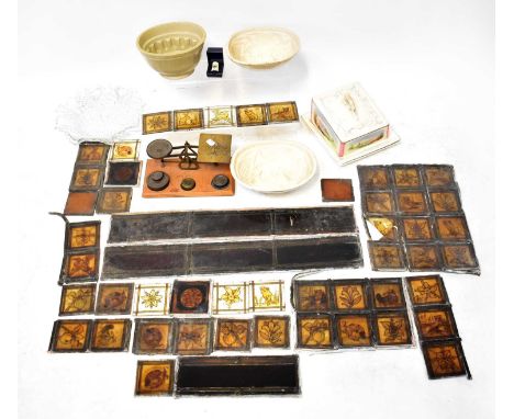 A collectors' lot comprising various stained glass leaded panels, a Victorian pottery cheese dish, three jelly moulds, a 20th