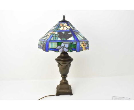 A Tiffany style lampshade of octagonal pyramid shape, with leaded bright flowers, height 22cm, diameter 36cm, resting on a br