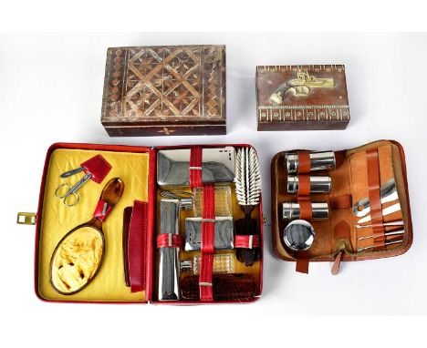 A vintage wooden box set with a metal relief decoration of a pistol, a larger wooden inlaid box, and two vintage travel vanit