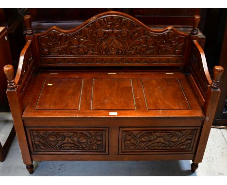 A modern wooden bench, with carved panels and storage seating area, 82 x 101 x 49cm.