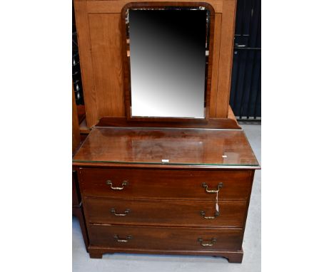 An early 20th century mahogany dressing chest with adjustable arch-topped bevelled mirror, above a base of three long drawers