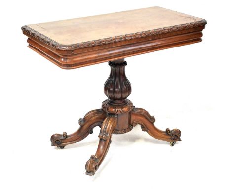 A mid-19th century rosewood fold-over card table, with red baize liner, raised on reeded baluster column and four carved outs