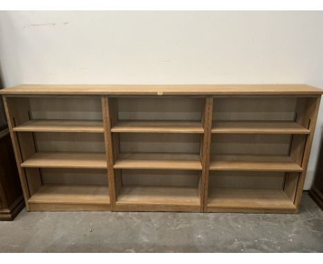 A light oak open bookcase in three sections, each part with two adjustable shelves. 102'w x 45'h