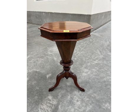 A Victorian walnut trumpet work table with octagonal top on facetted tapered well and tripod support