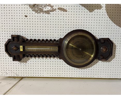 An oak aneroid wall barometer with brass dial and temperature register. 31' high