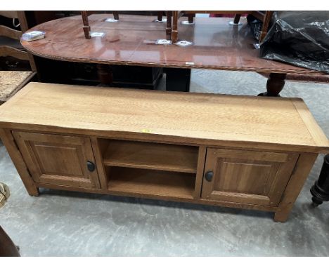 A light oak low cupboard with recess flanked by cupboard doors. 59' wide