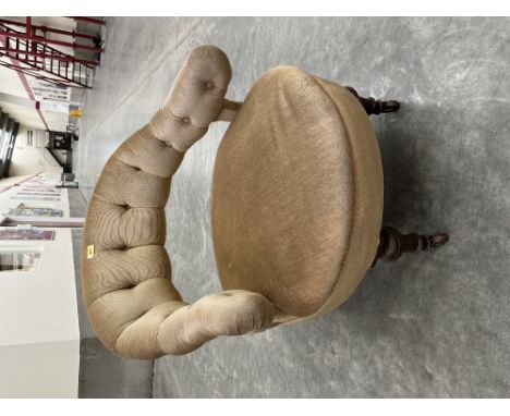 A Victorian upholstered tub armchair on walnut turned legs with ceramic castors