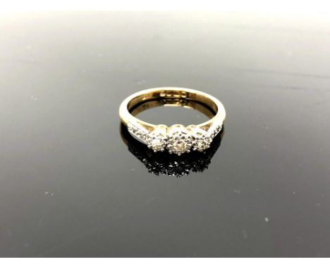 An 18ct yellow gold three stone diamond ring, set with diamond shoulders, size K/L, 3.1g.