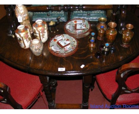 An oak oval gate-leg table on barley twist supports