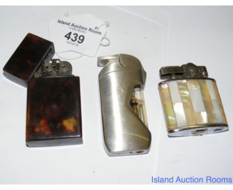 An old Zippo pocket lighter in faux tortoiseshell casing, together with two others
