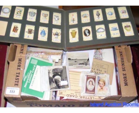 A box containing vintage maps, cigarette cards, photographs, etc.