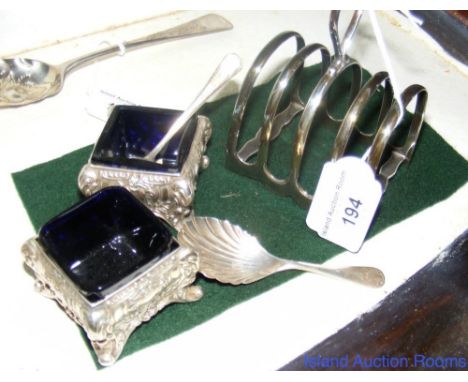 Pair of silver salts with blue glass liners, a silver "Shell" caddy spoon and ditto four slice toast rack