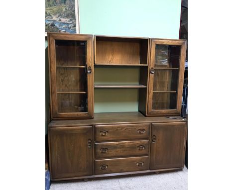 A Vintage Ercol display cabinet made from elm wood and sectioned cabinets. Measures 160x155x44cm 