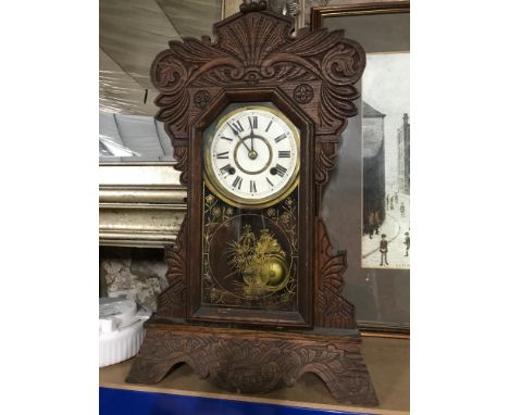 Antique American Ginger bread mantel clock, with key and pendulum. In a working condition. Measures 58cm in height 