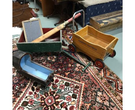 A Childs vintage pull along wagon, slate school board, cricket bat, Dolls cradle and one other pine pull along wagon. 