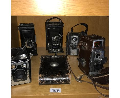 A Lot of vintage cameras which includes Bell &amp; Howell cine camera, Kodak bellow cameras and Coronet box camera. 