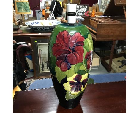 A Large Moorcroft Hibiscus pattern table lamp. In a working condition. Measures 42cm in height includes light fitment. 