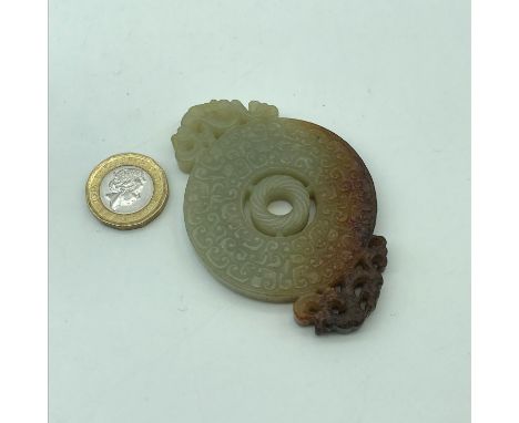 A Chinese carved jade sculpture pendant. Showing dark brown tinges. Measures 7.8cm in length 