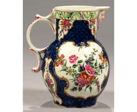 A WORCESTER SCALE BLUE GROUND CABBAGE LEAF MASK JUG, C1770&nbsp;painted in bright enamels with flowers and festoons, 20cm h, 