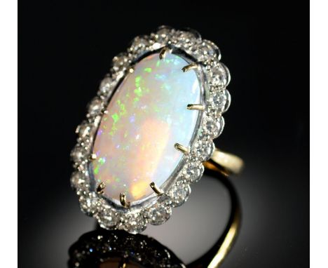 AN OPAL AND DIAMOND RING&nbsp; the 10 x 19mm oval opal of fine polish, in gold marked 18ct, 7.8g, size M Good condition