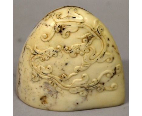 A CHINESE BOULDER FORM SOAPSTONE SEAL, the side decorated with confronting dragons, the beige stone with red inclusions, the 