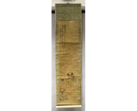 A CHINESE HANGING SCROLL PICTURE, within a patterned surround, decorated with calligraphy and two ladies seated at a table, s