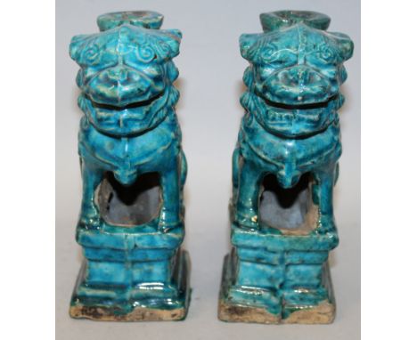 A PAIR OF CHINESE MING DYNASTY TURQUOISE GLAZED POTTERY JOSS STICK HOLDERS, each in the form of a buddhistic lion seated on a