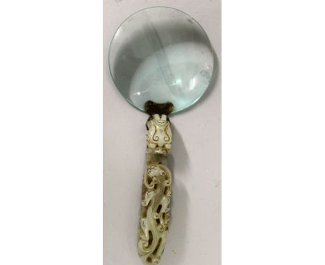 A 19TH CENTURY CHINESE JADE HANDLED MAGNIFYING GLASS, the handle formed from a celadon jade belt hook, the stem carved in rel