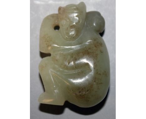 A CHINESE CELADON GREEN JADE PENDANT CARVING OF A SEATED MONKEY, the stone with lighter and darker inclusions, 1.5in high.