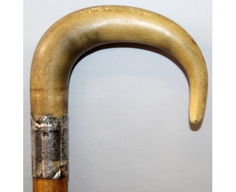 A 19TH CENTURY RHINOCEROS HORN HANDLED WOOD WALKING STICK, with a hallmarked silver collar, the curved yellowish-amber horn w