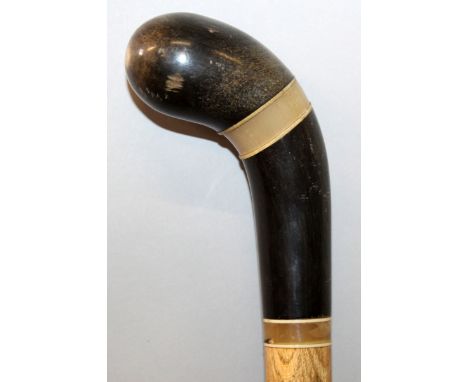 A FINE QUALITY 19TH CENTURY RHINOCEROS HORN HANDLED WOOD WALKING STICK, the blackish horn with a tight grain and mounted with