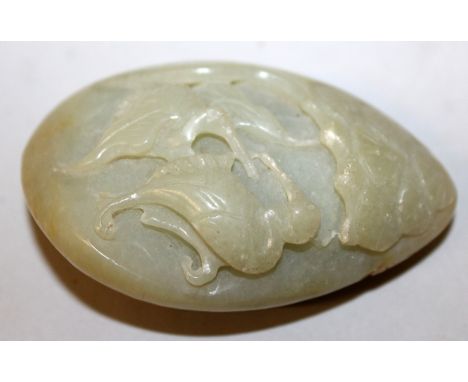 A CHINESE CELADON JADE-LIKE PEBBLE, decorated in deep relief to one side with a pair of phoenix, 2.75in long.