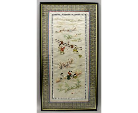 A 20TH CENTURY FRAMED CHINESE EMBROIDERED SILK PANEL, within a patterned silk mount, depicting two groups of playing boys, th