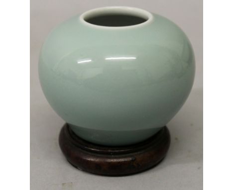 A CHINESE CELADON GLAZED WATER POT, together with a fitted wood stand, the sides applied with an even glaze pooling slightly 