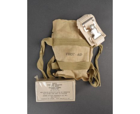 Pochette First Aid Parachutiste US. Housse en toile impermeabilise kaki. Marquage First Aid. Les sangles sont presentes et vi